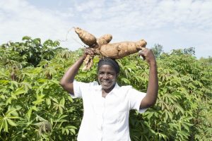 Farmer Damaris with cassava on her head