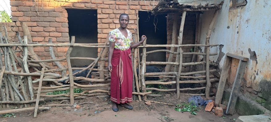 Melia stands outside her home, Mulanje District, Malawi.