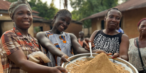 Nigerian women holding a plate of Tom Brown